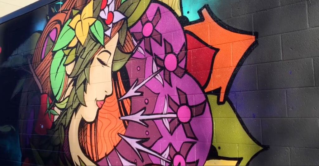 Image of a mural painted on brick wall of a woman with flowers in her hair