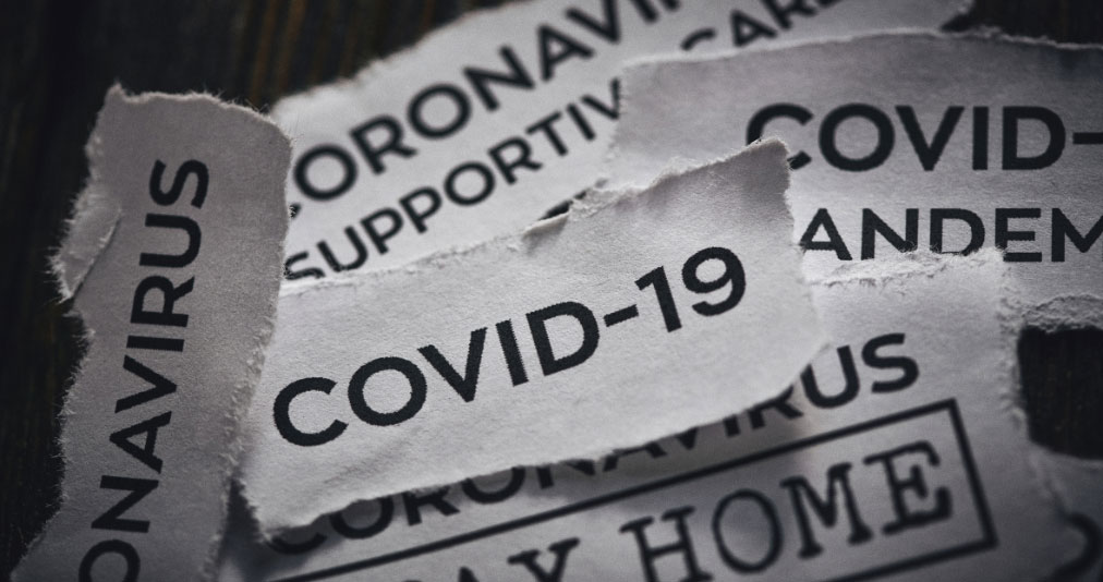 Torn sheets of paper with Coronavirus and COVID-19 written on them