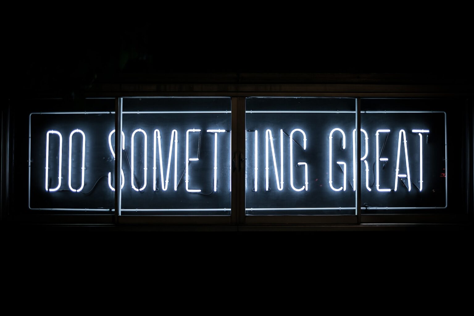 Neon sign with the words "Do Something Great"